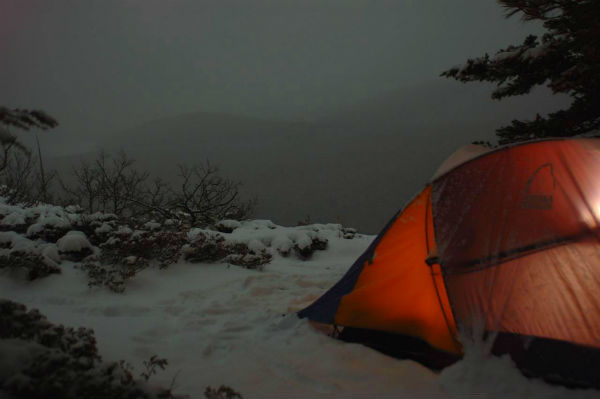 Kufahl's camp at dusk. Over a foot of new snow fell overnight, covering the bushes on the left and partially collapsing the tent.