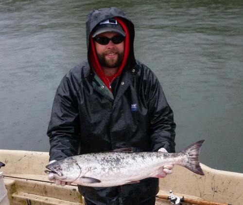 Kevin Gray shows off an ocean fresh hatchery Chinook caught during a downpour