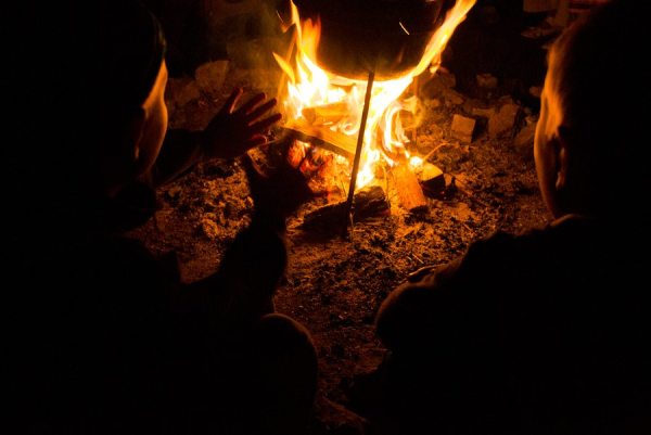 children sit around the campfire at night