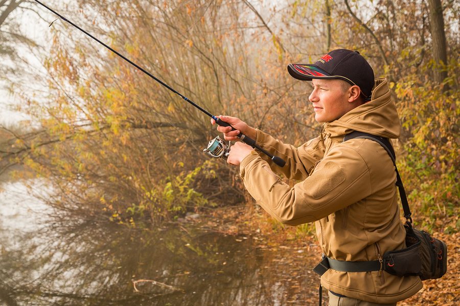 Fisherman on the river bank. Autumn fishing.