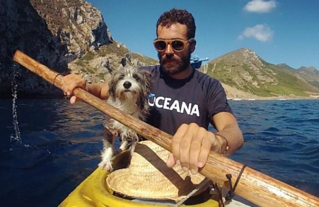 man and dog in kayak