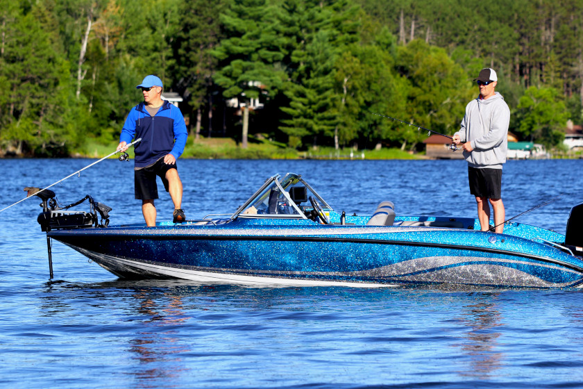 Two anglers fishing from a bass boat.