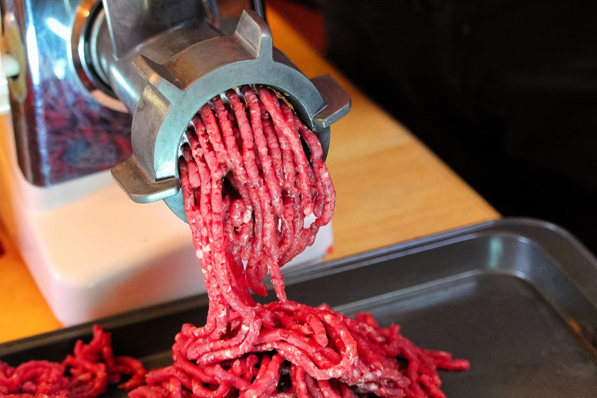 Red meat coming out of meat grinder.