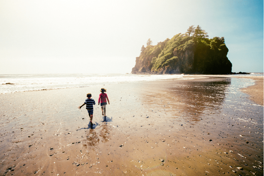 Children playing with the waves at Ruby Beach in Olympic National Park. Washington State. USA.