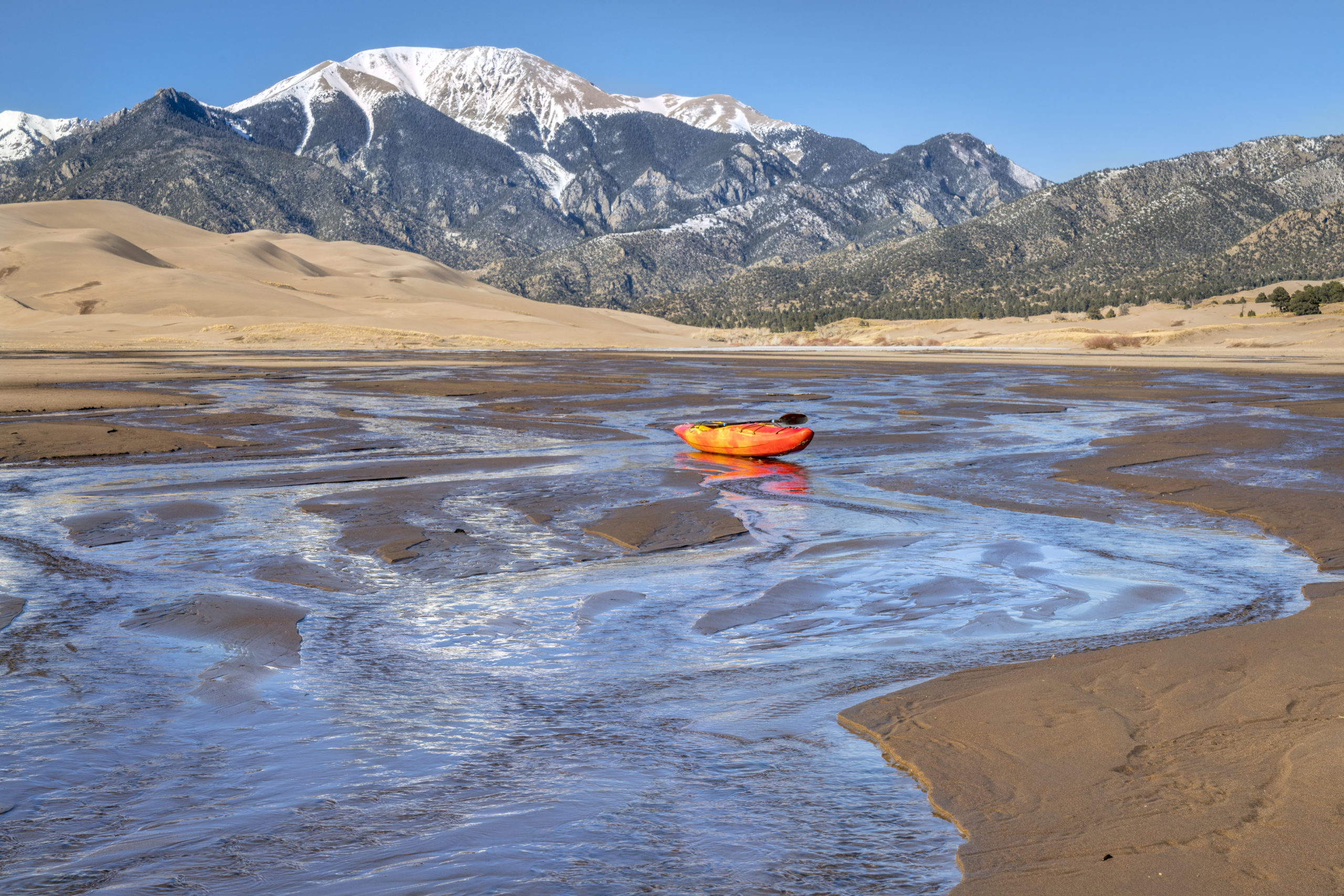 whitewater kayak in shallow water and sand dunes
