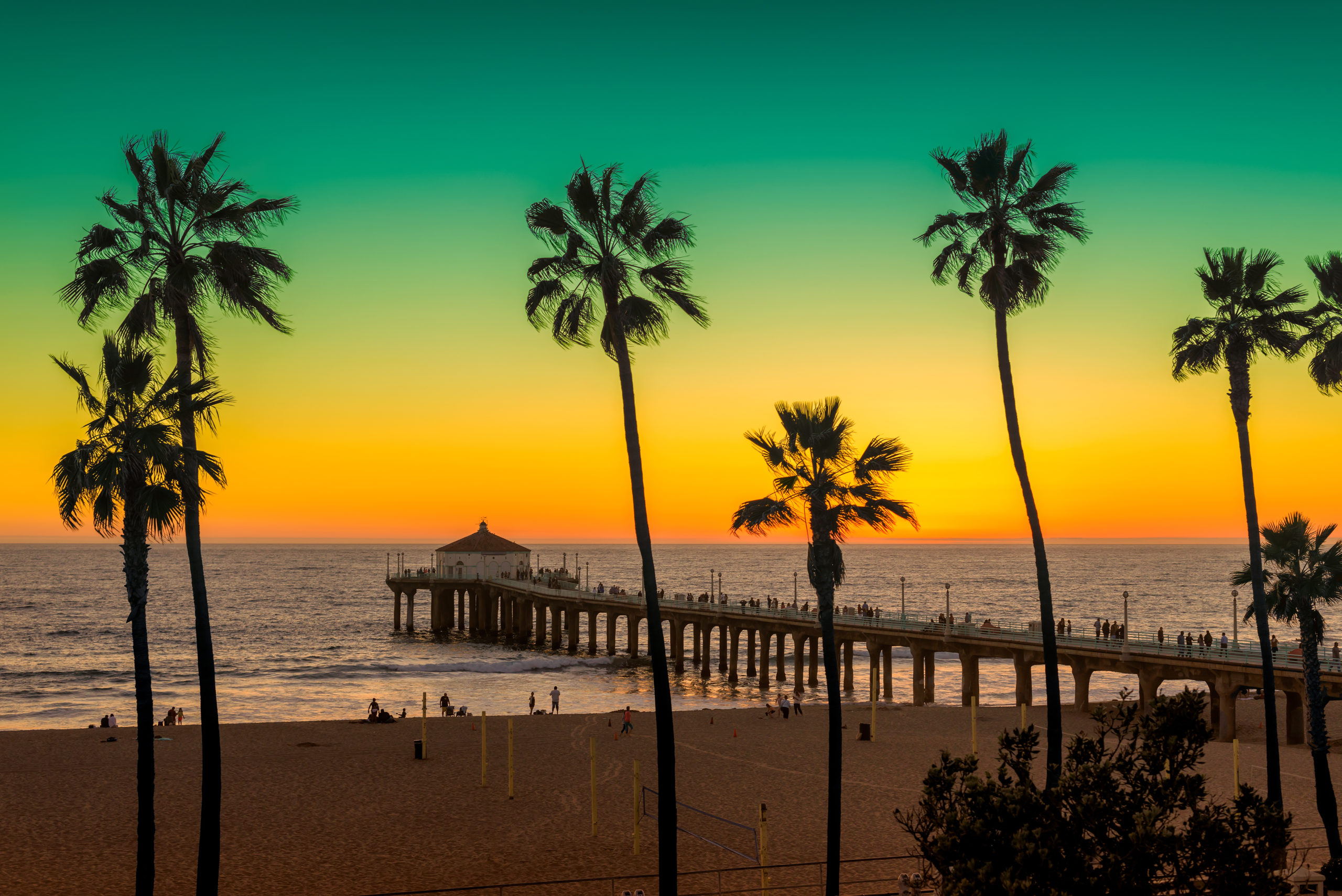Manhattan Beach with Palm trees and pier at sunset in Los Angeles, California. Vintage processed. Fashion travel and tropical beach concept.