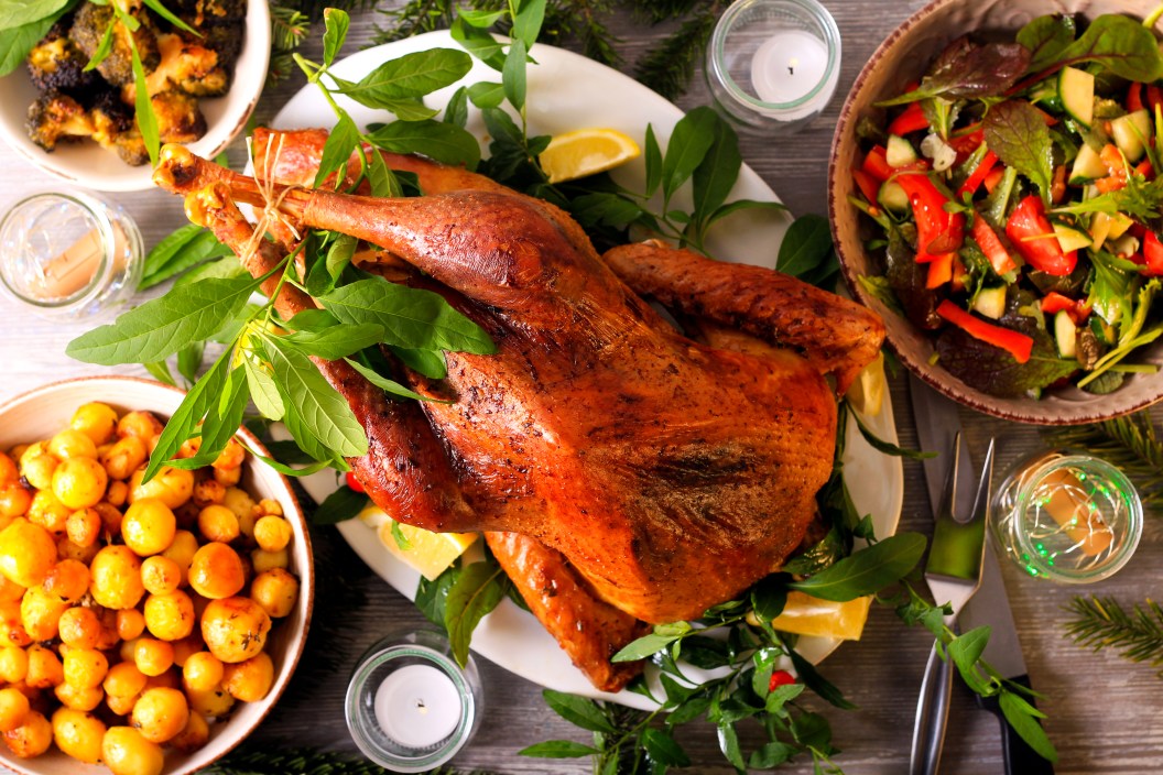 Festive dinner with roast wild turkey and other dishes served on table