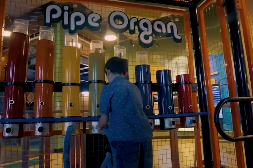 a young boy plays at the pipe organ activity at the children's discovery museum