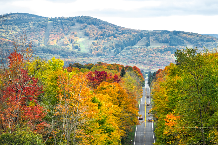 West Virginia road highway with many cars traffic in colorful autumn fall near Blackwater Falls State park and Seneca Rocks with steep ski resort slope hill