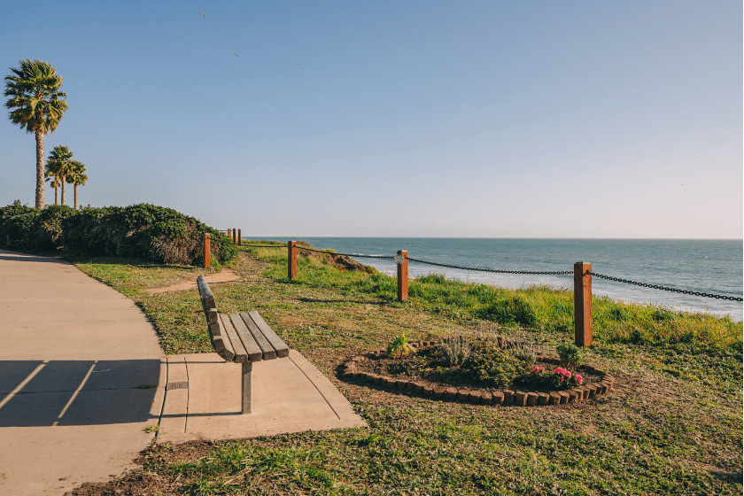 Walkway along the shore and wooden bench overlooking the ocean, California Central Coast