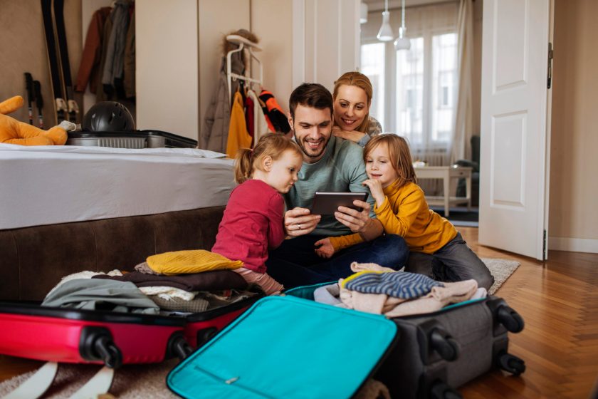 family using tablet while packing for a vacation