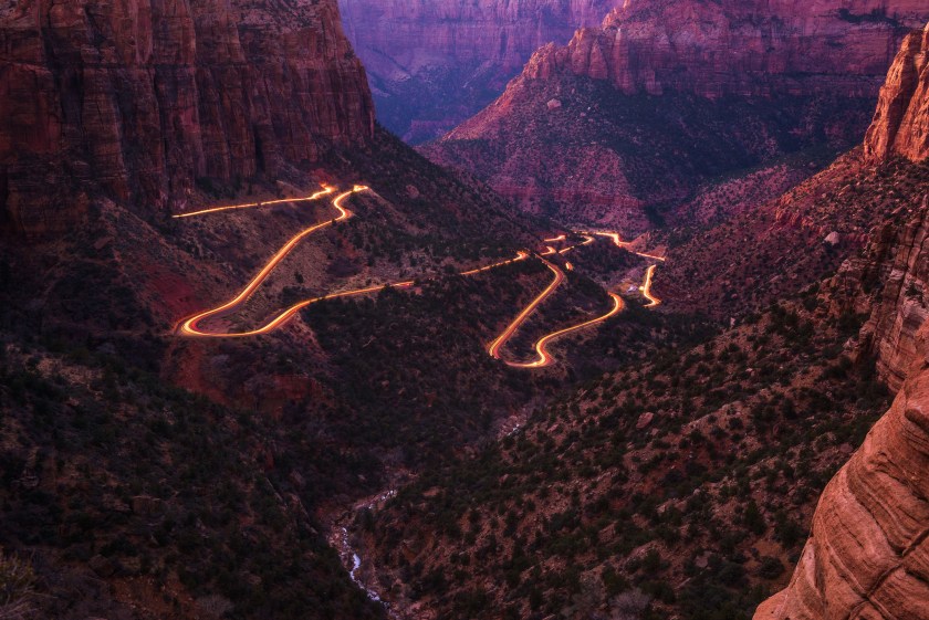 Zion Canyon and Mount Carmel Highway with car light trails seen from Canyon Overlook in Zion National Park, Utah, USA.