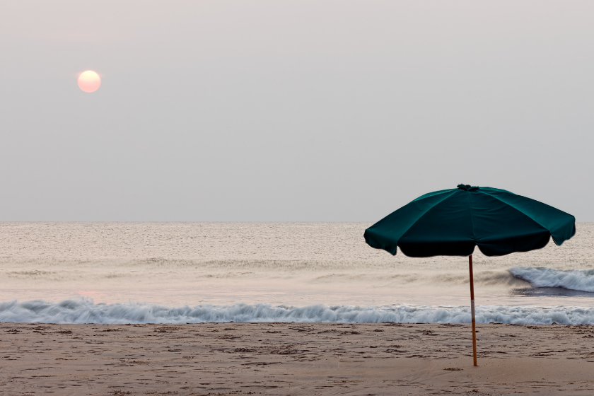 A soft sunrise on an overcast morning on the North Carolina shore with a beach umbrella