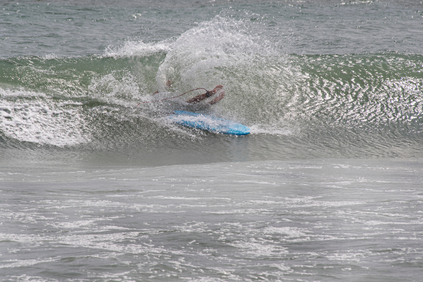 A surfer wipes out and is covered by a wave at Emerald Isle, North Carolina