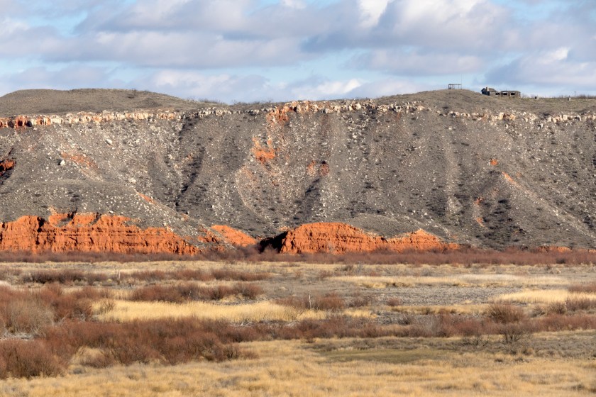 On the edge of eroded sandstone cliffs stands an abandoned ranch house above the Canadian River canyon of the Lake Meredith National Recreation Area in Texas.