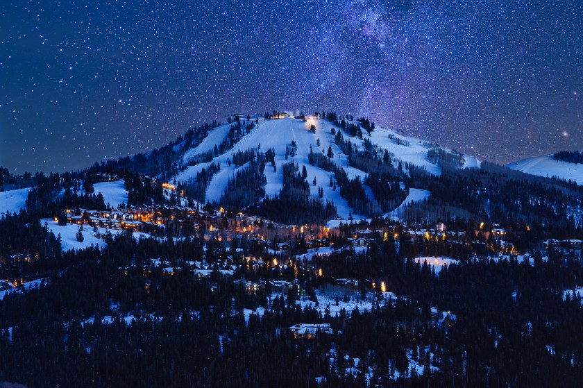 Dusk View of Park City Glowing. Scenic village from above with cool blue dusk light and glowing warm lights. Dusk View of Park City Glowing