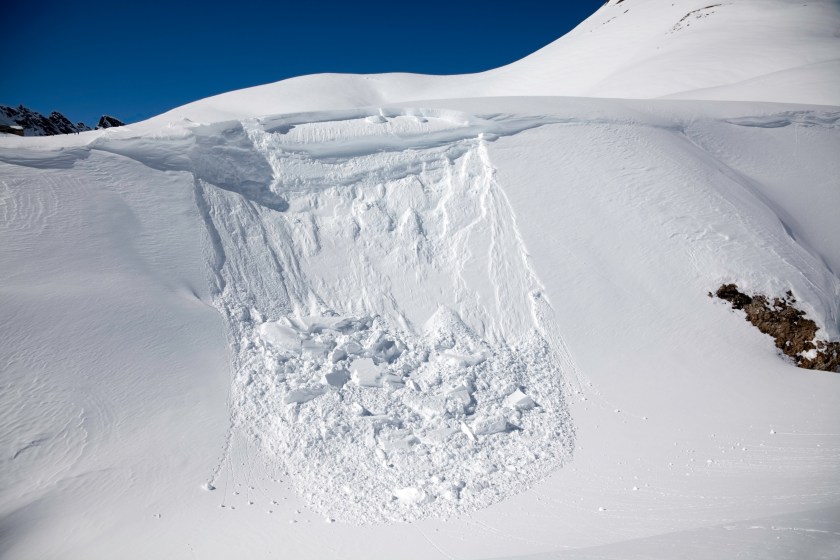 The start of an avalanche on a hillside.