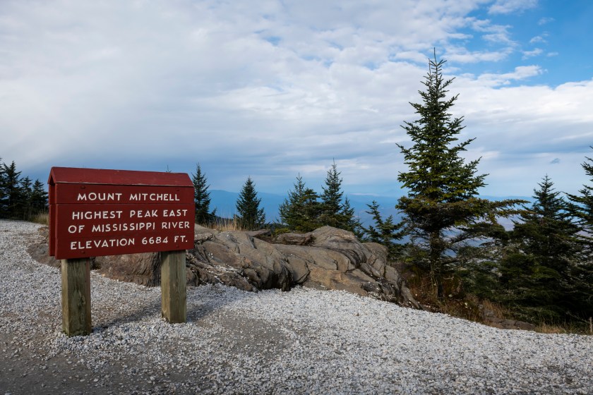 A sign near the observation platform at the summit of Mount Mitchell reads: "Mount Mitchell, highest peak east of Mississippi River Elevation 6684 feet".