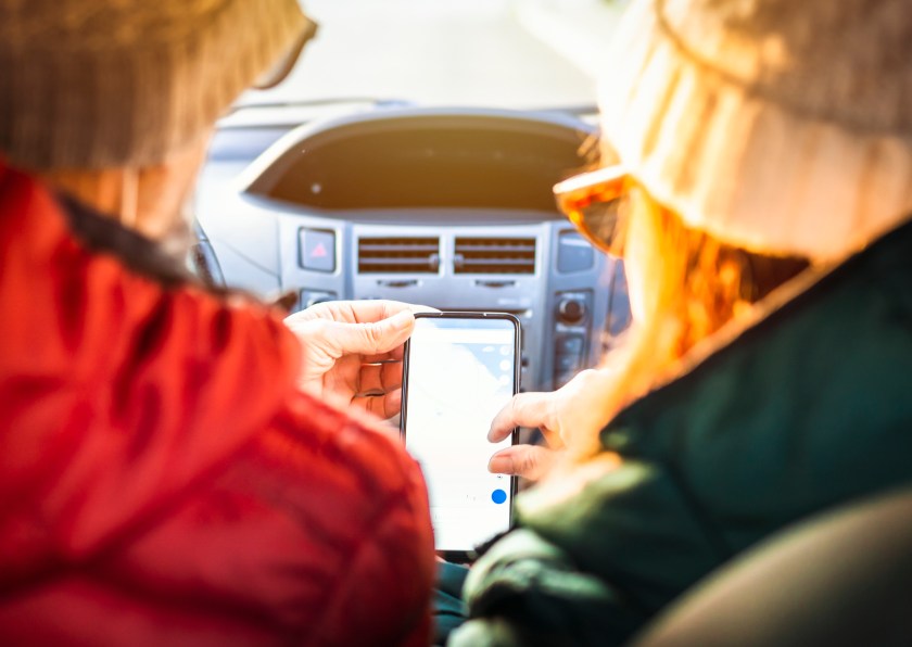 Retirees check the directions on their smart phone using gps - Middle aged couple on vacation enjoying their free time