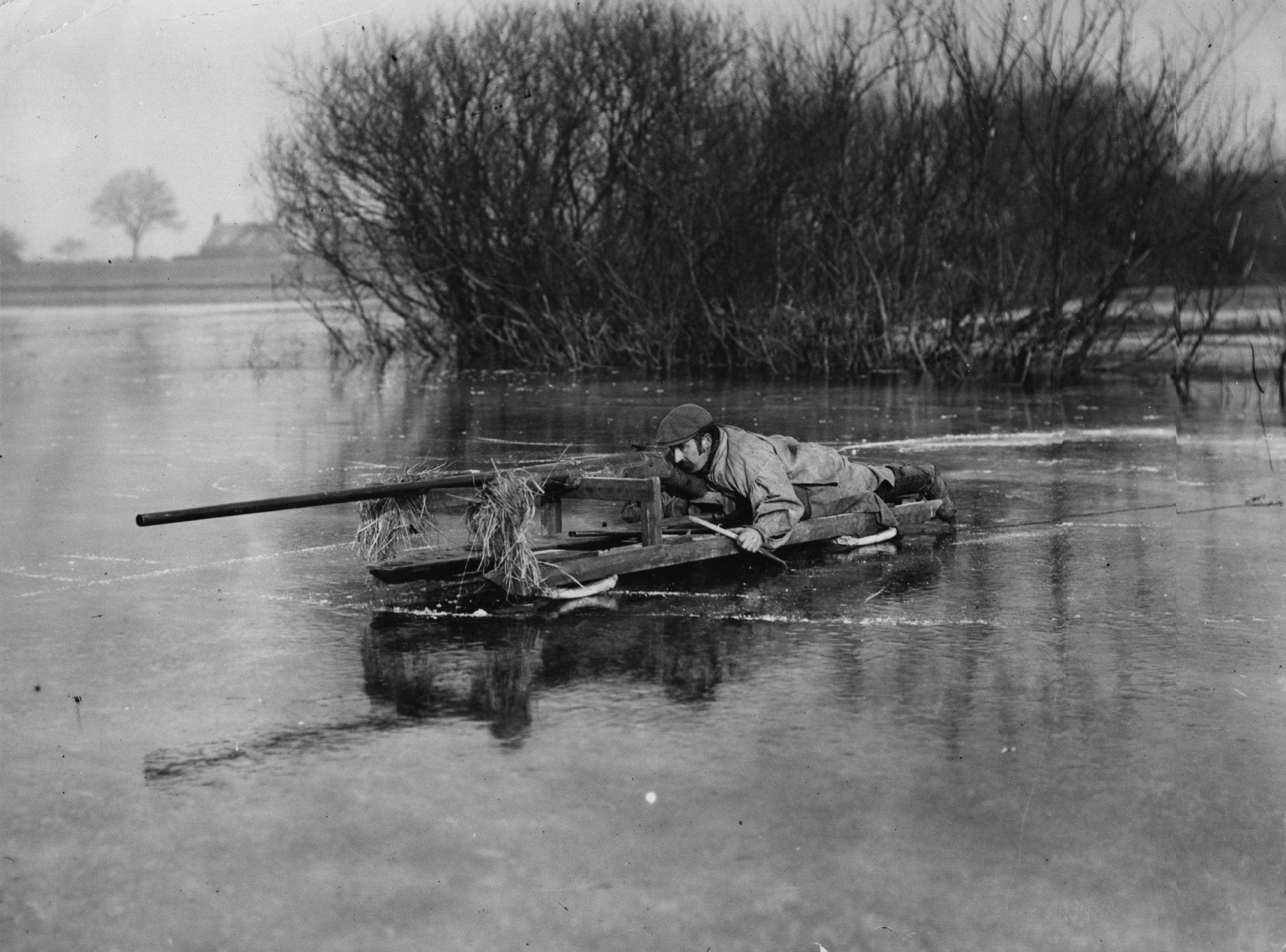 A duckshooter stalking birds on a sledge with a punt gun, on the frozen waters of Crowbit Wash in the Fens. (Photo by Topical Press Agency/Getty Images)