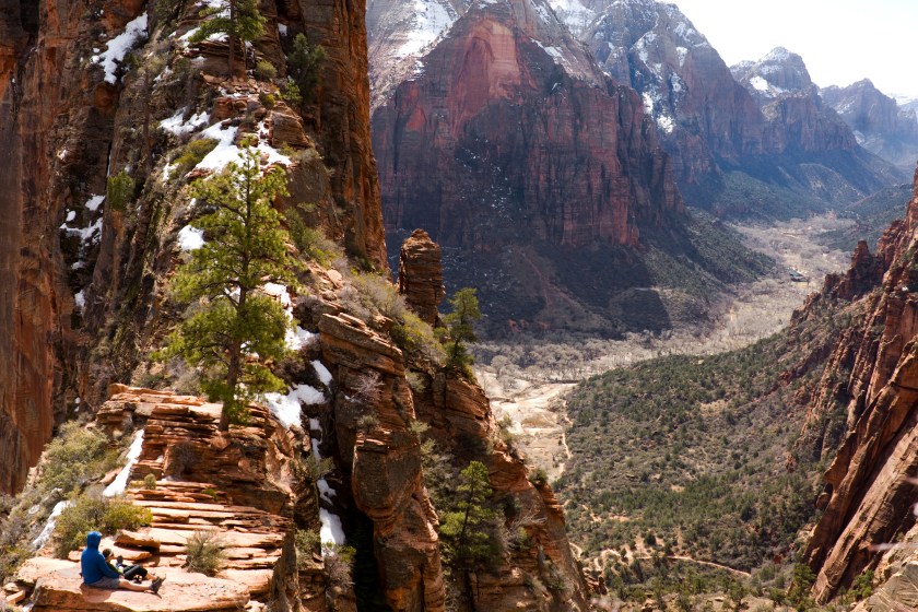 A couple sits atop of Angels Landing in Zion National Park.