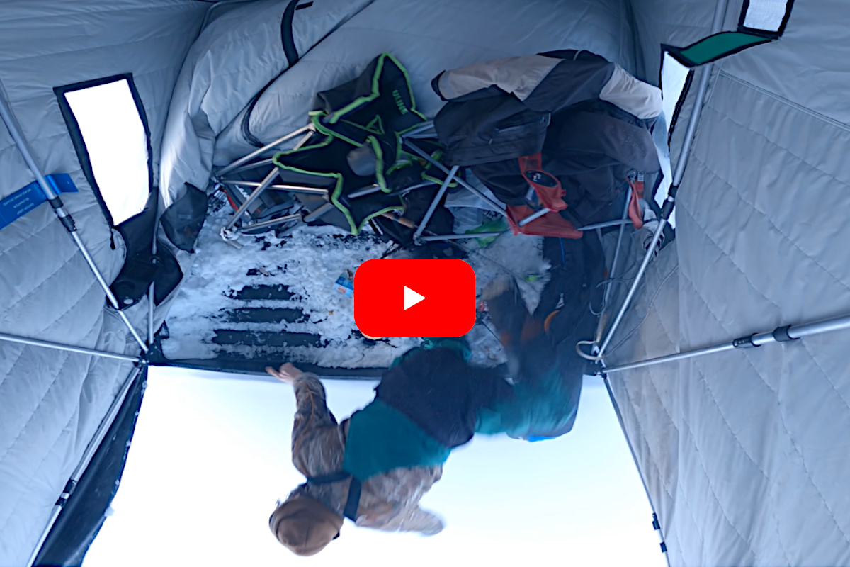 Angler getting towed across the ice in his fishing shelter.