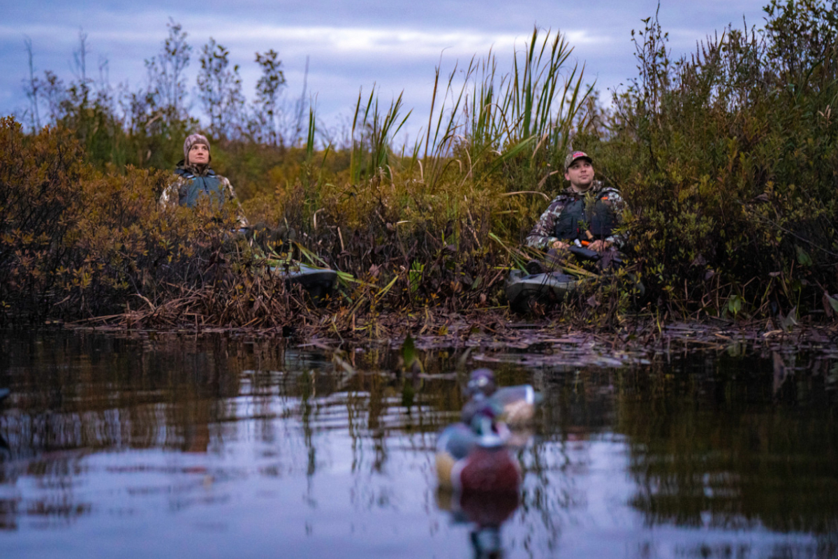 Two hunters targeting ducks from kayaks.