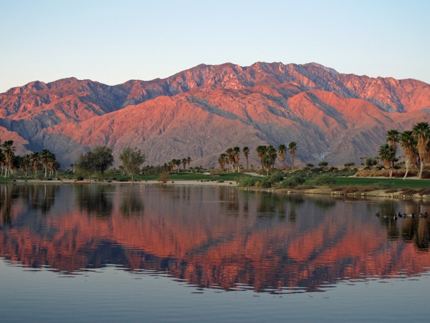 The mountains are kissed by the sunrise on a desert golf course near Palm Springs, California.