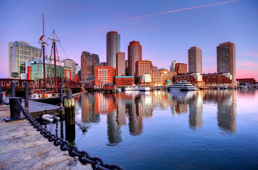 Downtown Boston Skyline along the Boston Harbor Waterfront. Photo taken along the harborwalk in the South Boston southie neighborhood. The Boston cityscape is a mixture of old and new buildings. Boston is the capital and largest city in Masssachusetts. Boston is the largest city in New England