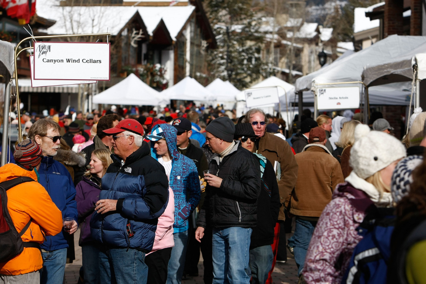 a crowd gathers around food tents during the day