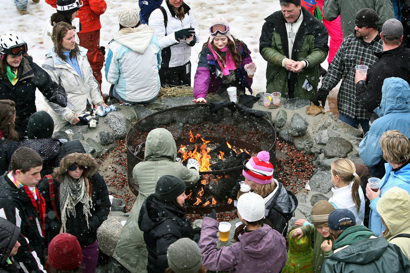 The crowd warms up around the fire pit on the "Beach"