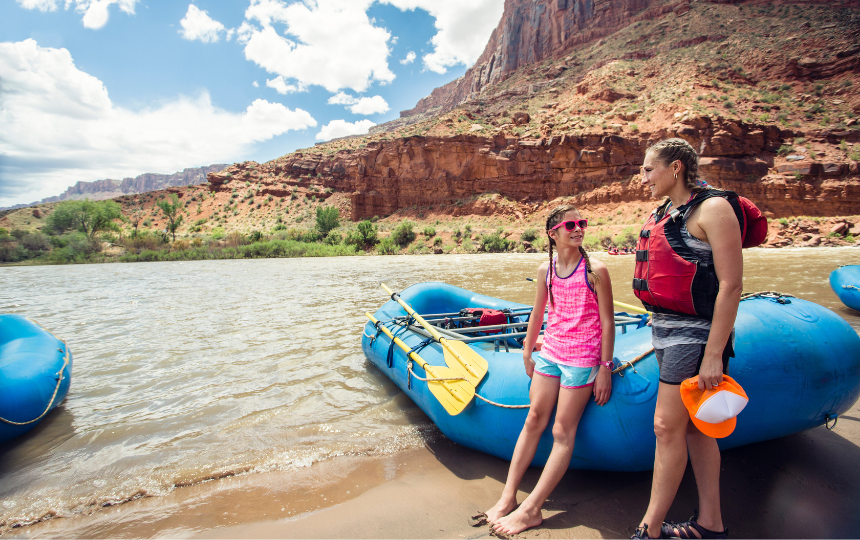 Smiling child and adult women ready to board a large inflatable raft as they travel down the scenic Colorado River near Moab, Utah and Arches National Park