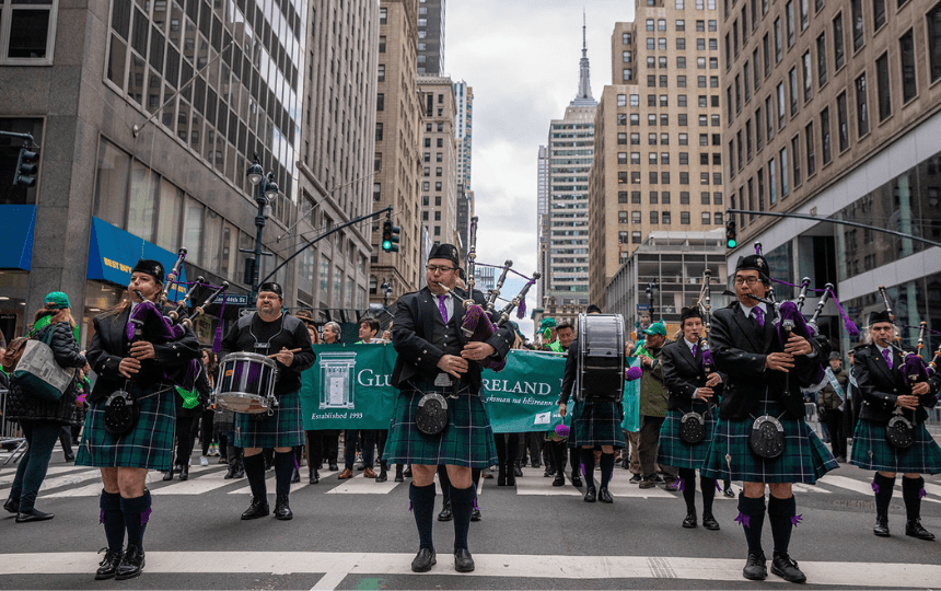 Men in kilts play bagpipes and drums in downtown New York City