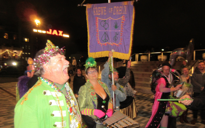 a man dressed in green yells jubilantly during a night-time parade 