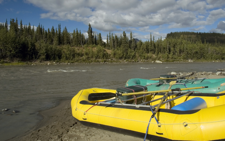 two rafts sit at the shore of a river in a forest