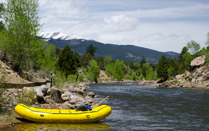 A yellow river raft sits empty on the side of the Arkansas River in Buena Vista, Colorado.