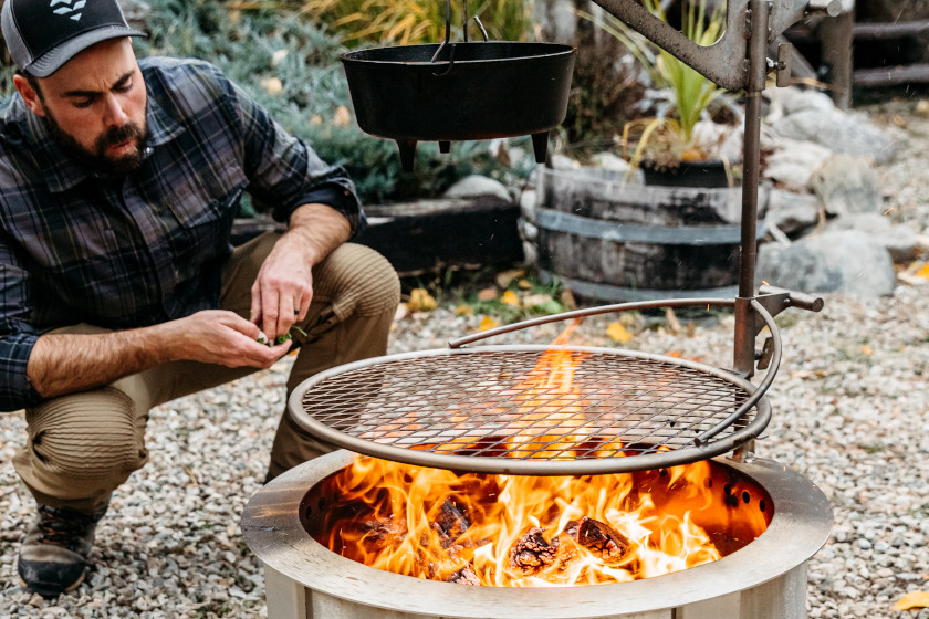 Hunting personality Remi Warren cooking over a fire.