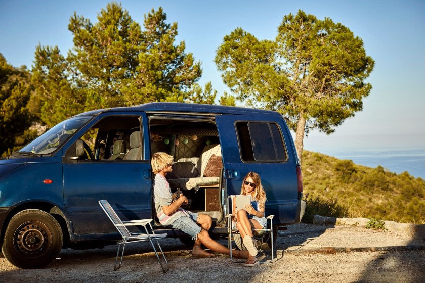 Girlfriend and boyfriend are sitting by converted mini van