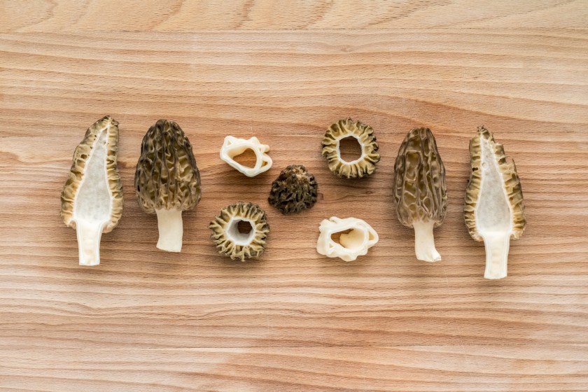 Slices of morel mushrooms on wooden cutting board - detail from kitchen