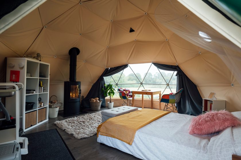 Interior of the living space of a space-age style dome tent at a glamping site