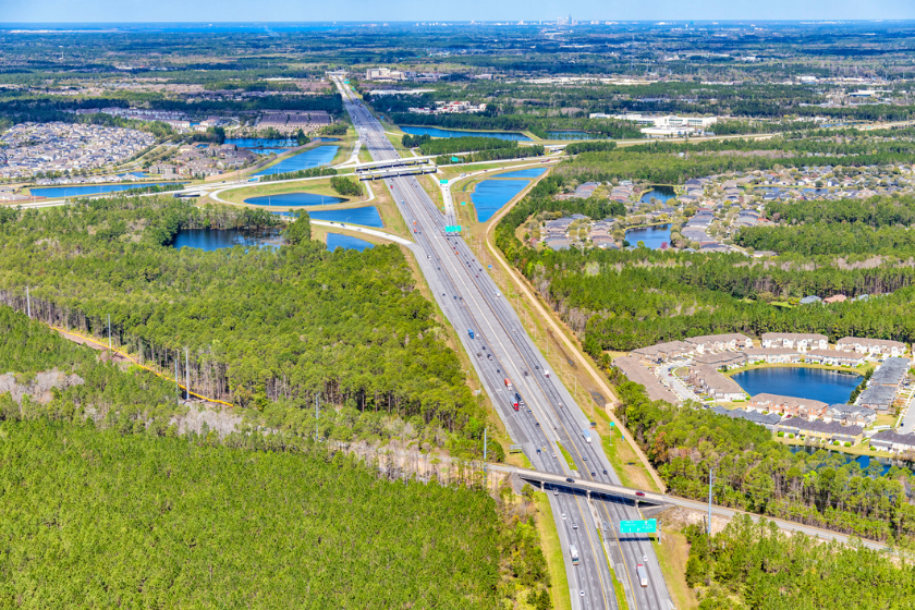 Aerial view of an interstate 95 ramp located in Florida just south of Jacksonville with the city's skyline in the distance.
