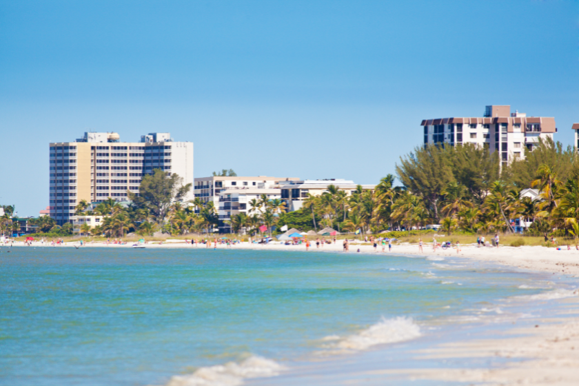 The skyline of Fort Meyers Beach in Fort Meyers, along the gulf coast of Florida, USA with tourists, vacationers on the beach, and resort hotels in the background. 