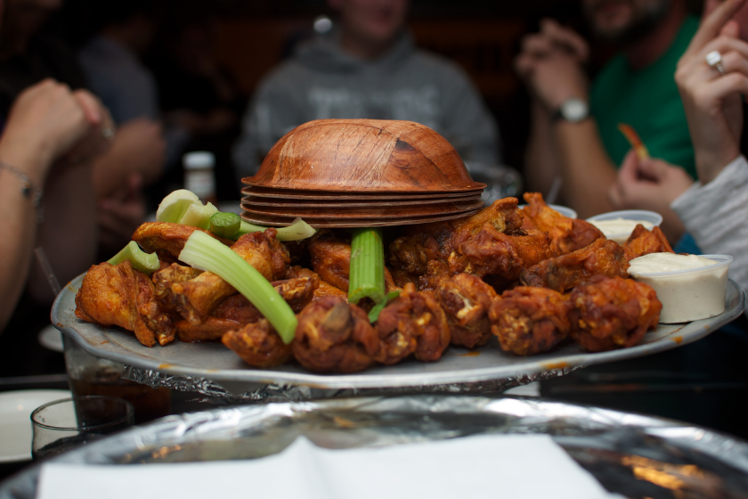 A bowl of chicken (Buffalo) wings and celery.