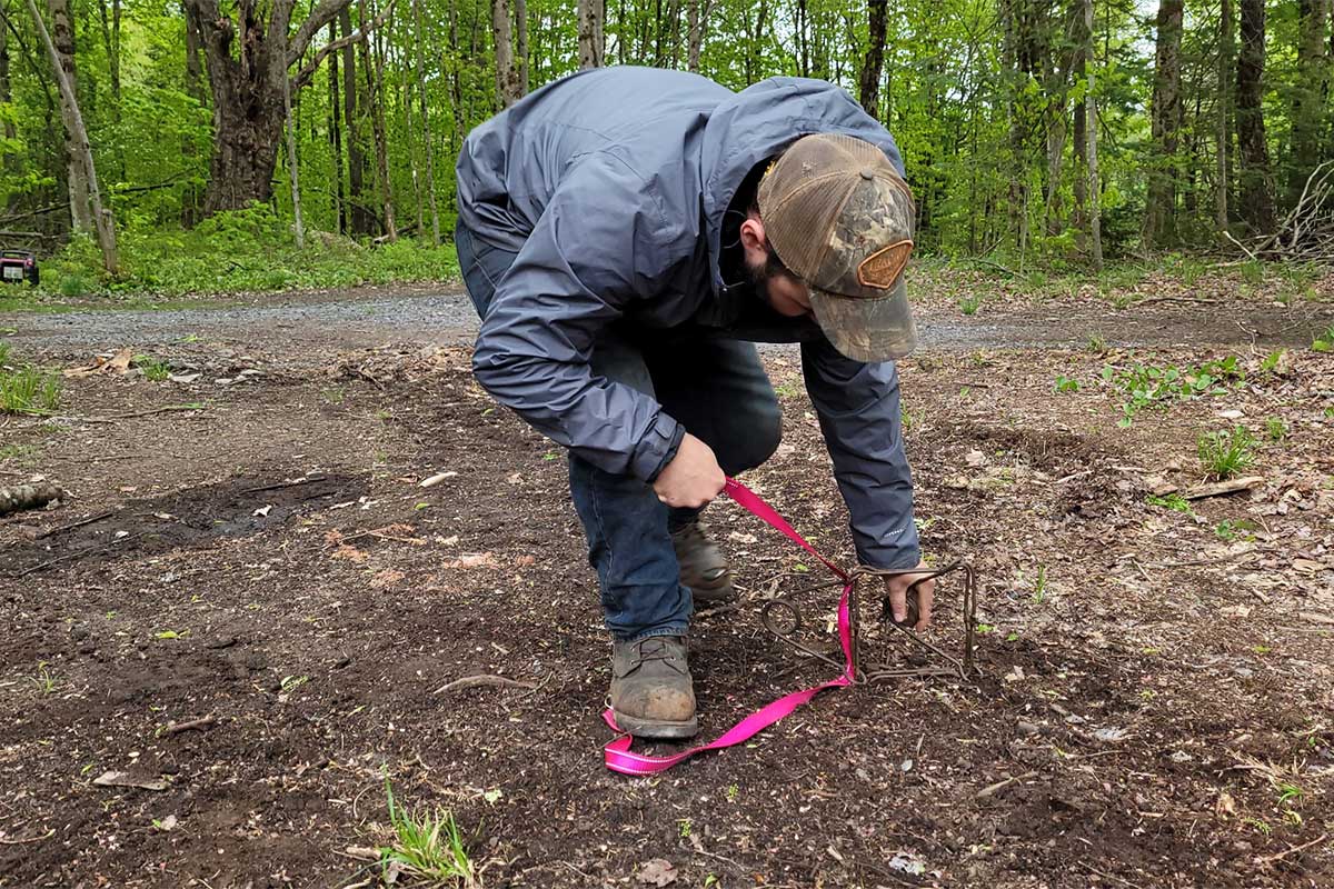 Trapper Bill Plete demonstrates how to open a closed trap with a dog leash.