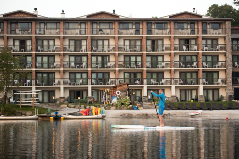 Man kayaking on Mirror Lake in front of Golden Arrow Lakeside Resort