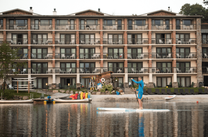 Man kayaking on Mirror Lake in front of Golden Arrow Lakeside Resort