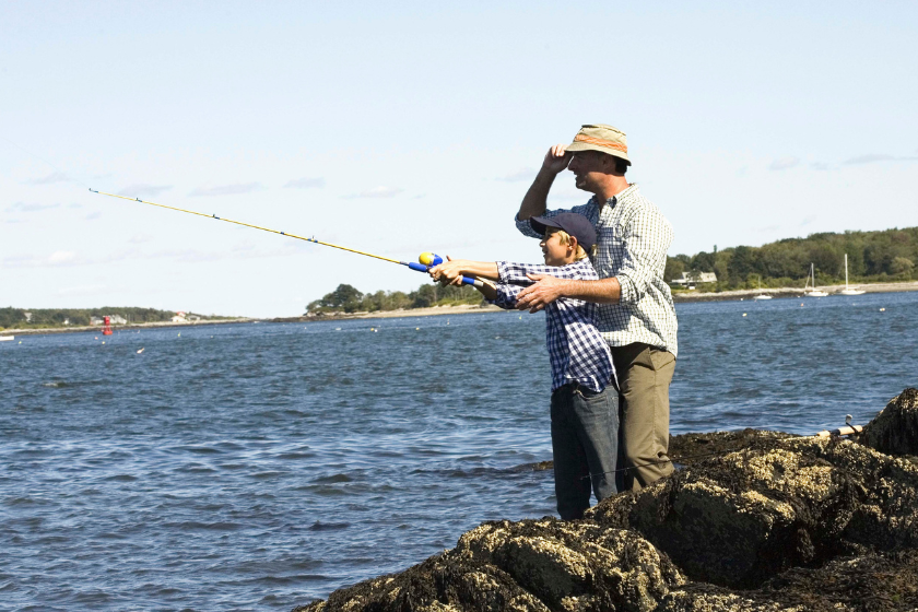 Father and son fishing on shore 