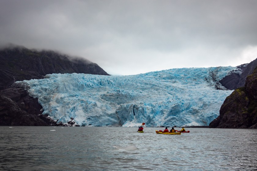 Kayakers paddling near glaciers at Kenai Fjords National Park in Alaska.