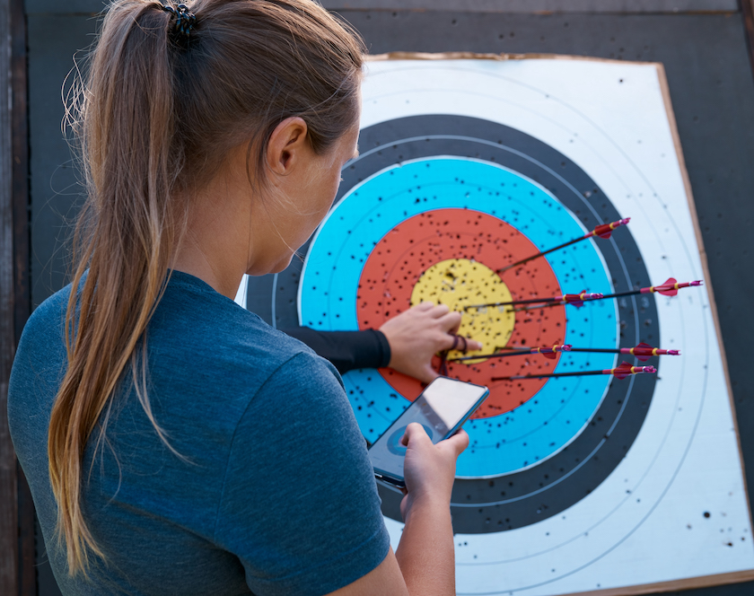 Rearview shot of an unrecognizable female archer practicing her craft out on the archery range 