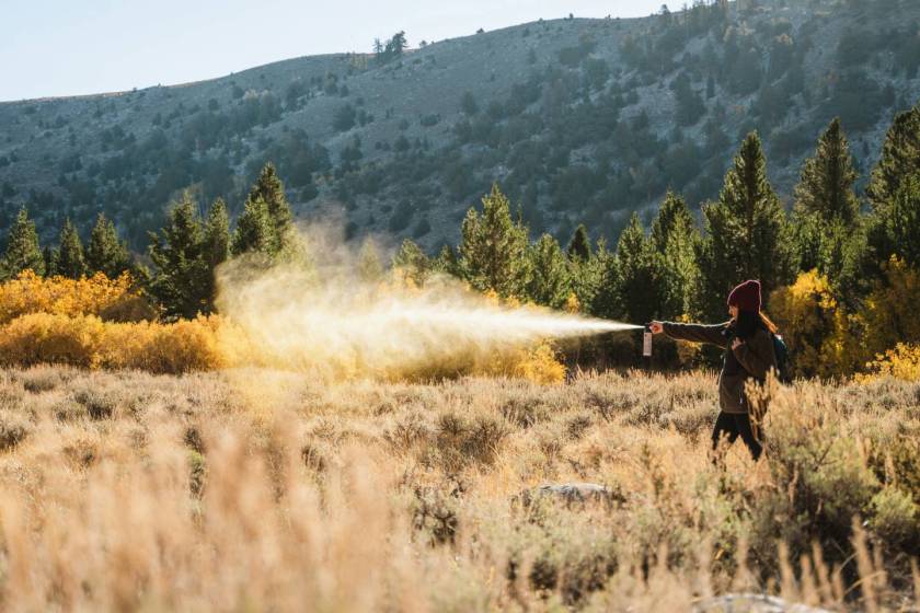 woman outdoors spraying bear spray by sabre frontiersman